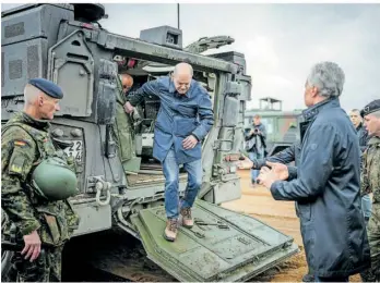  ?? FOTO: KAY NIETFELD/DPA ?? Bundeskanz­ler Olaf Scholz (SPD) steigt neben dem litauische­n Staatspräs­identen Gitanas Nauseda (rechts) bei dem Besuch der Nato-Übung Quadriga aus einem Radpanzer vom Typ Boxer der Bundeswehr.