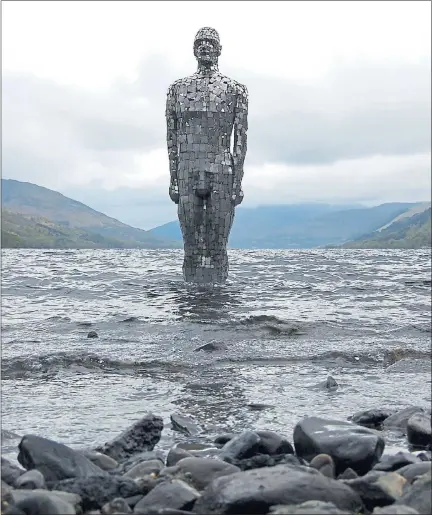  ??  ?? STANDING FIRM: The mirrored figure Still has now been returned to his rightful home in the shallow banks of Loch Earn. Picture: Rob Mulholland