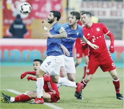  ?? — AP ?? DARMSTADT: Munich players (red) and Darmstadt players challenge for the ball during a German first division Bundesliga soccer match between Darmstadt 98 and Bayern Munich in Darmstadt, Germany, yesterday.