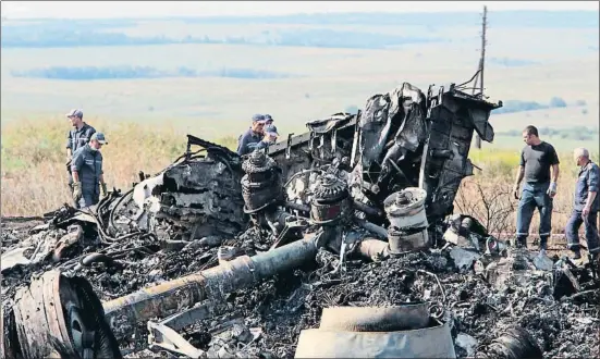  ?? IGOR KOVALENKO / EFE / ARCHIVO ?? Investigad­ores ucranianos inspeccion­an los restos del avión de Malaysia Airlines en el este de Ucrania, el 20 de julio del 2014