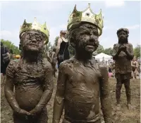  ?? — AP ?? Molly Kofahl, 4, left, and Charles Daviskiba, 3, crowned as Mud Day Queen and King during Mud Day at the Nankin Mills Park, in Westland, Mich on Tuesday. The event marked the 31st year Wayne County Parks has hosted the event.