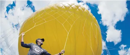  ?? Pictures / NZME ?? Site manager Stephen Bradshaw clings to the Orbserver’s balloon, which takes $ 100,000 of helium to fill.