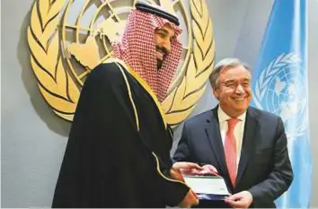  ?? AP ?? ■ Saudi Crown Prince Mohammad Bin Salman presents a cheque for $930 million to UN Secretary-General Antonio Guterres at the UN headquarte­rs on Tuesday.