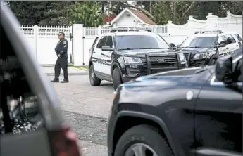  ?? Karsten Moran/The New York Times ?? A police officer stands outside the home of Bill and Hillary Clinton on Wednesday in Chappaqua, N.Y.