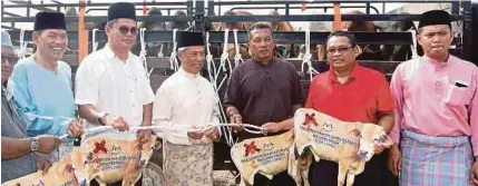  ?? [Foto Adi Safri /BH] ?? Muhyiddin bersama wakil jabatan dan agensi yang menerima sumbangan lembu korban pada Majlis Penyerahan Lembu Korban Parlimen Pagoh di Taman Pagoh Jaya, semalam.