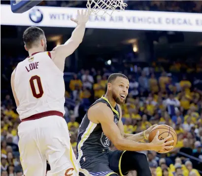  ?? AP ?? Golden State Warriors guard Stephen Curry (right) shoots against Cleveland Cavaliers forward Kevin Love. —