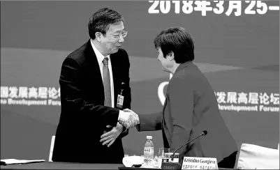  ?? WANG ZHUANGFEI / CHINA ?? Yi Gang, newly elected governor of the People’s Bank of China, greets Kristalina Georgieva, chief executive officer of the World Bank, at the China Developmen­t Forum 2018 in Beijing on Sunday.