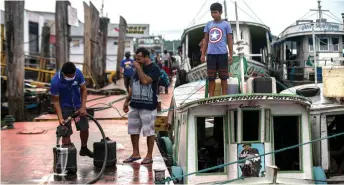  ?? — AFP photo ?? People from riverside communitie­s fill gallons with fuel to depart on a boat, in the port zone of the city of Breves, southwest of the Marajo Island, an island at the mouth of the Amazon River in the Brazilian state of Para, amid the Covid-19 coronaviru­s pandemic.