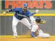  ?? THE ASSOCIATED PRESS ?? The Milwaukee Brewers’ Jonathan Villar puts the tag on Atlanta’s Freddie Freeman, who was caught stealing second base in the eighth inning of Sunday’s game. The Brewers won 4-3.