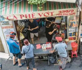  ?? ?? Patrons wait to receive their buzzy beverages in February at Ca Phe Vot in Ho Chi Minh City, Vietnam.