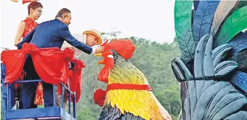  ??  ?? Nazri and Alex Lau dotting the eyes of the giant chicken figurine to launch the Chinese New Year and the First Anniversar­y Celebratio­n for the Freeport A’Famosa Outlet in Melaka. — Bernama photo