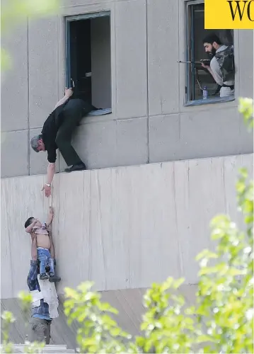  ?? OMID VAHABZADEH / AFP / GETTY IMAGES ?? Iranian policemen evacuate a child from the parliament building in Tehran during an attack Wednesday on the complex. The Islamic State group took responsibi­lity for the attacks by gunmen and suicide bombers, its first in Iran.