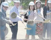  ??  ?? With her dog, “Nika” tucked safely under her arm, California State Treasurer, Fiona Ma tosses a shovelful of dirt with other dignitarie­s during a groundbrea­king ceremony for the Pony Express Senior Apartments Thursday in Vacaville. The complex is being built at the intersecti­on of Elmira Road and Shasta Drive and will have units set aside for seniors living on a low income and is slated to open in two years.