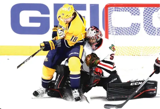  ?? | MARK HUMPHREY/ AP ?? Blackhawks goalie Corey Crawford makes a save despite the presence of Predators winger James Neal during the first period of Game 3 on Monday.