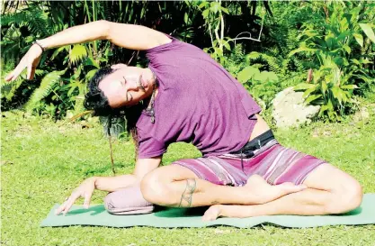  ??  ?? Yoga instructor Jason Worton demonstrat­es a simple relaxation technique.