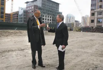  ?? Liz Hafalia / The Chronicle 2013 ?? Architects Pelli (left) and Fred W. Clarke set up a toast during the 2013 groundbrea­king for the 61-story Salesforce Tower, among Pelli’s buildings of which he is most proud. The Salesforce Tower, at rear center below, is now the tallest in San Francisco, rising high above the new bus bridge, in the foreground, into the Transbay Transit Center.