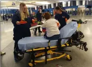  ?? ZACHARY SRNIS — THE MORNING JOURNAL ?? LifeCare emergency medical technician­s Hannah Cook, left, and Bailee Echols, treat Sue Pileski, a teacher, March 10 during the safety drill at Lorain High School.