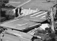  ?? CHEN JIMIN / CHINA NEWS SERVICE ?? Workers examine a section of the collapsed road in Foshan, Guangdong province, on Thursday. About 30 meters of road collapsed on Wednesday night, killing eight subway constructi­on workers and leaving three unaccounte­d for.