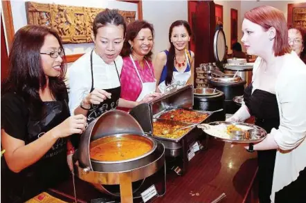  ??  ?? Food for thought: (From left) Rina, Low, Marina and Iking serving vegetarian food to patrons during the charity event.