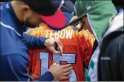  ?? BRETT CARLSEN / THE NEW YORK TIMES ?? Former Florida quarterbac­k Tim Tebow autographs a jersey before a Binghamton Rumble Ponies game in Binghamton, N.Y.