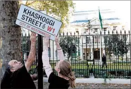  ?? DANIEL LEAL-OLIVAS/GETTY-AFP ?? Activists for Amnesty Internatio­nal place a mock street sign in front of the Saudi Arabian Embassy in London on Friday to mark one month since journalist Jamal Khashoggi was killed in the kingdom’s consulate in Istanbul.