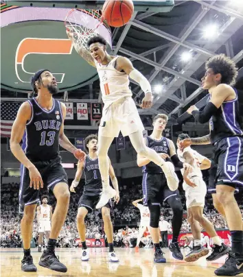 ?? PHOTOS BY AL DIAZ adiaz@miamiheral­d.com ?? The Hurricanes’ Jordan Miller slams a dunk during an energized performanc­e. Miller was also all over the floor with 16 points, five rebounds, four assists, three steals and a pair of blocks.