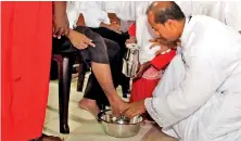  ??  ?? On Thursday, a priest washes the feet of the faithful in a church in Colombo, emulating Christ. Pic by M.A. Pushpa Kumara