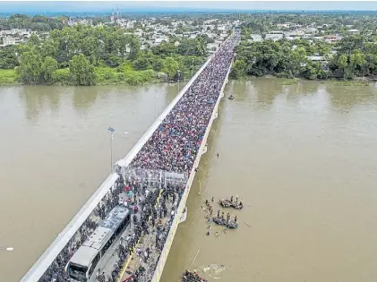  ?? AFP ?? Puente. Cientos de familias abarrotaro­n la frontera entre Guatemala y México. Algunos cruzan en balsas.