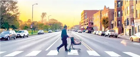  ?? PROVIDED ?? Jarrett Knize wheels his Illinois-record bighead carp across North Avenue in a shopping cart in a classic photo by Daisy Schultz.