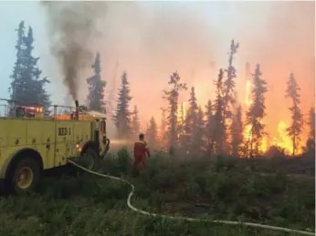  ?? GOVERNMENT OF SASKATCHEW­AN/THE CANADIAN PRESS ?? A crew battles a blaze in the La Ronge area of northern Saskatchew­an on Saturday. The Alberta government says it expects to receive up to 5,000 people from the evacuation­s in the area.