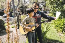  ?? Michael Short / Special to The Chronicle ?? Patricia Riestra holds sheet music for her son Mateo Aranguren as he plays “Happy Birthday” for Zona Roberts.