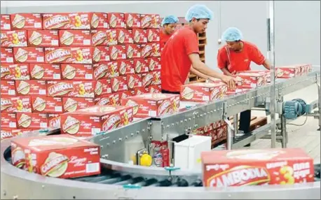  ?? MENG KIMLONG ?? Workers stack cases of Cambodia brand beer at the Khmer Brewery factory on the outskirts of Phnom Penh.
