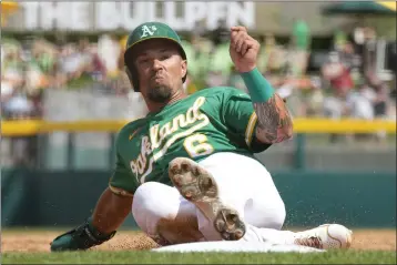  ?? ROSS D. FRANKLIN — THE ASSOCIATED PRESS ?? The A's Jace Peterson slides safely into third base against the Giants during the second inning of a spring training game on Friday in Mesa, Arizona.