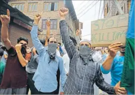  ?? AP PHOTO ?? Masked protesters raise slogans during a demonstrat­ion in Srinagar on Friday.