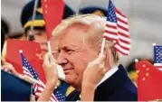  ?? Andrew Harnik / Associated Press ?? Children wave U.S. and Chinese flags Wednesday as President Donald Trump arrives in Beijing.