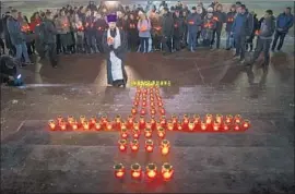  ?? Alexander Zemlianich­enko Associated Press ?? RUSSIAN Orthodox youths and a priest gather at Moscow’s Cathedral of Christ the Savior, where 71 candles were lighted for those killed in Sunday’s crash.