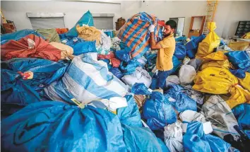  ?? AFP ?? A Palestinia­n postal worker sifts through sacks of undelivere­d mail at the central internatio­nal exchange post office in the West Bank city of Jericho on Tuesday.