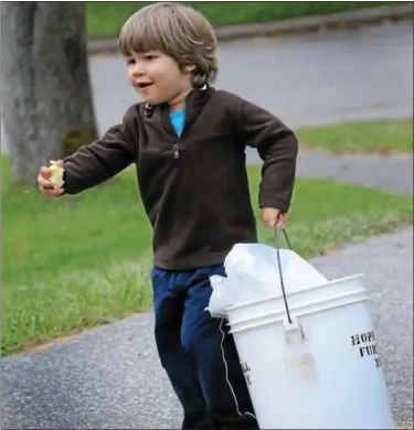  ?? DIGITAL FIRST MEDIA FILE PHOTO ?? In this file photo, Lucas Ubiera holds an apple he’s eating and carrying a bucket partially filled with apples that were picked in the orchard at Hopewell Furnace National Historic Site.