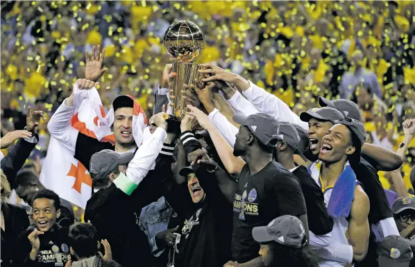  ?? MARCIO JOSE SANCHEZ/THE ASSOCIATED PRESS ?? Warriors players, coaches and owners hold up the Larry O’Brien NBA Championsh­ip trophy Monday after Game 5 of the NBA Finals against the Cavaliers in Oakland, Calif. The Warriors beat Cleveland, 129-120, to claim their second championsh­ip in three...