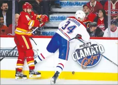  ?? Canadian Press photo ?? Flames’ Mark Giordano, left, checking Canadiens’ Michael McCarron in NHL action Thursday in Calgary, said the Flames are focusing on moving up in the standings.