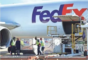  ??  ?? Fedex material handlers offload containers at the Memphis hub on Oct. 12. STAN CARROLL / THE COMMERCIAL APPEAL