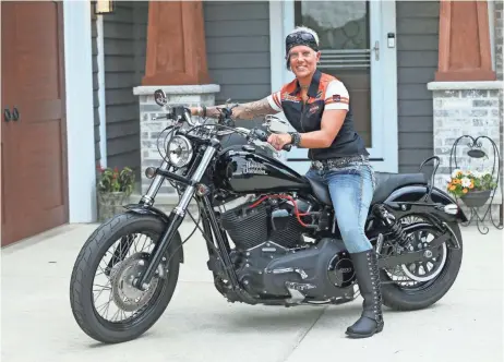  ?? MICHAEL SEARS / MILWAUKEE JOURNAL SENTINEL ?? Michelle Swanson sits on her 2014 Harley-Davidson Dyna Street Bob motorcycle at her home in Muskego. See more photos at jsonline.com/news.