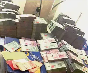  ??  ?? Large haul: Some of the cash recovered by the Immigratio­n Department during the raid at the hotel.