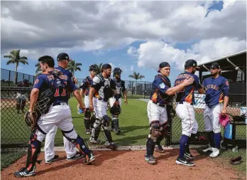  ?? Yi-Chin Lee / Houston Chronicle ?? Astros catchers leave the bullpen after practicing with the team’s pitchers at Fitteam Ballpark of The Palm Beaches on Day 1 of spring training Thursday in West Palm Beach. The Astros will play the Washington Nationals on Feb. 23 in their Grapefruit League opener.