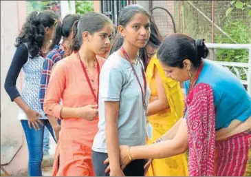  ?? PRABHAKAR SHARMA/HT PHOTO ?? Staff member checks students’ IDs at Maharani College during RU students union polls on Friday.