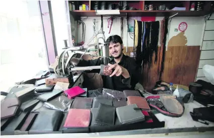  ?? Christophe­r Pike / The National ?? Shah Mohammed hard at work in his Abu Othman Shoe Repair Shop on Najda Street, Abu Dhabi.