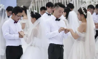  ??  ?? Newlywed couples attend a group wedding ceremony at Juzizhou Island Landscape in Changsha, Hunan Province of China in May 2020. Photograph: China News Service/Getty Images