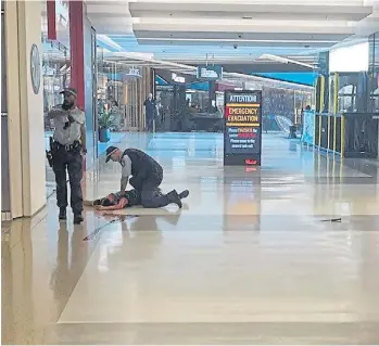  ?? AFP ?? Tensión. Dos policías rodean a una de las víctimas del ataque en el mall de Sidney.