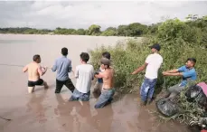  ??  ?? Migrantes varados intentan cruzar el Río Goascorán, que comparten Honduras y El Salvador, EFE