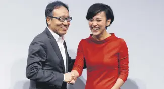  ??  ?? CEO of Softbank Mobile Corp. Ken Miyauchi (L) and President of Didi Chuxing Jean Liu shake hands after a press conference on their joint venture in Tokyo, July 19.